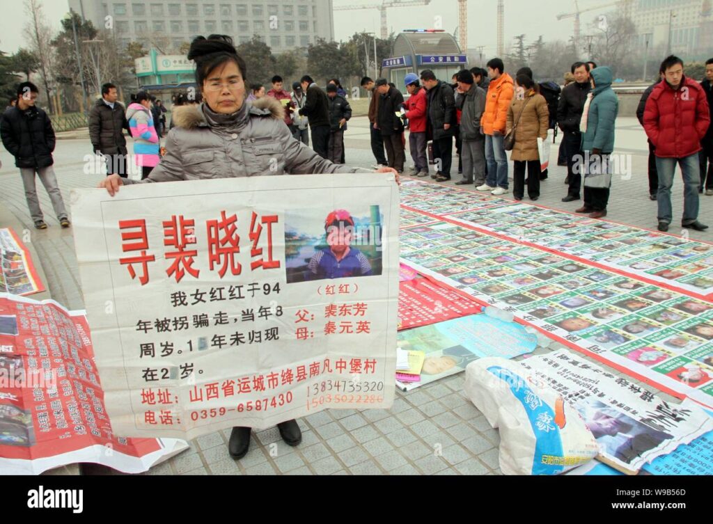 a chinese parent shows a poster printed with a photo and information of her abducted daugther on a square in jinan east chinas shandong province jan w9b56d